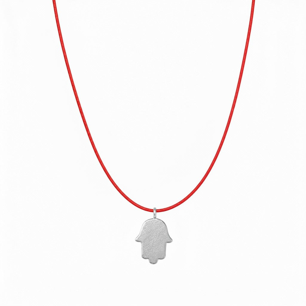 אופק אדלר אואה תכשיטים SANTA men's necklace featuring a large sterling silver hamsa pendant on a red cord.