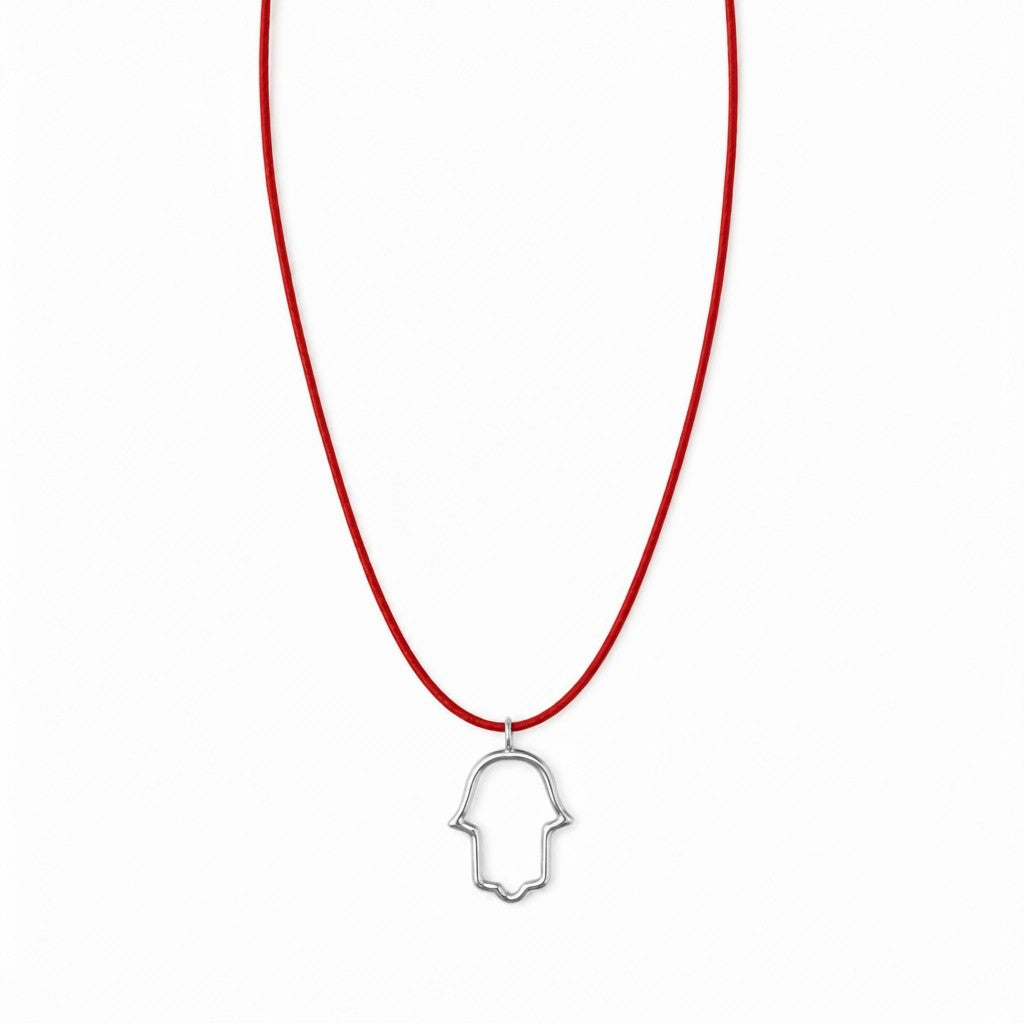 אופק אדלר אואה תכשיטים Santa men's necklace featuring a silver hollow hamsa pendant on a thin red cord.